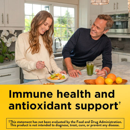 Man and woman in a kitchen with fruits and a glass of juice, promoting immune health and antioxidant support.